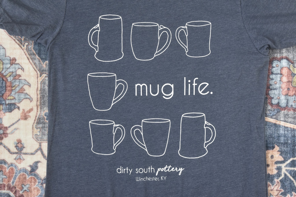 Navy Blue Unisex Tank with illustrated mugs in square design and "mug life" on second row, with "Dirty South Pottery, Winchester, KY" written underneath. Design & photos copyright Dirty South Pottery, LLC 2024