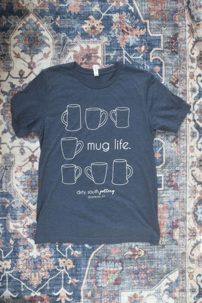Navy Blue Unisex Tank with illustrated mugs in square design and "mug life" on second row, with "Dirty South Pottery, Winchester, KY" written underneath. Design & photos copyright Dirty South Pottery, LLC 2024