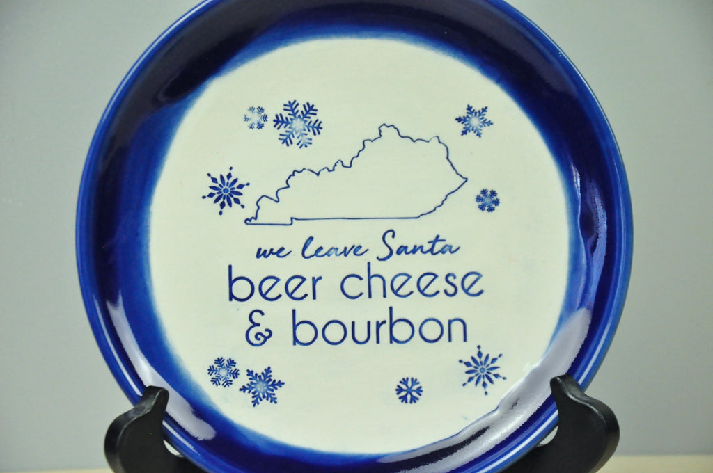 Handmade blue plate with 'we leave Santa beer cheese and bourbon" , the state of Kentucky, and snowflakes stamped into it. Gift for bourbon enthusiast, bourbon gift idea, gift for parents, bourbon decor, Santa plate, Kentucky gift