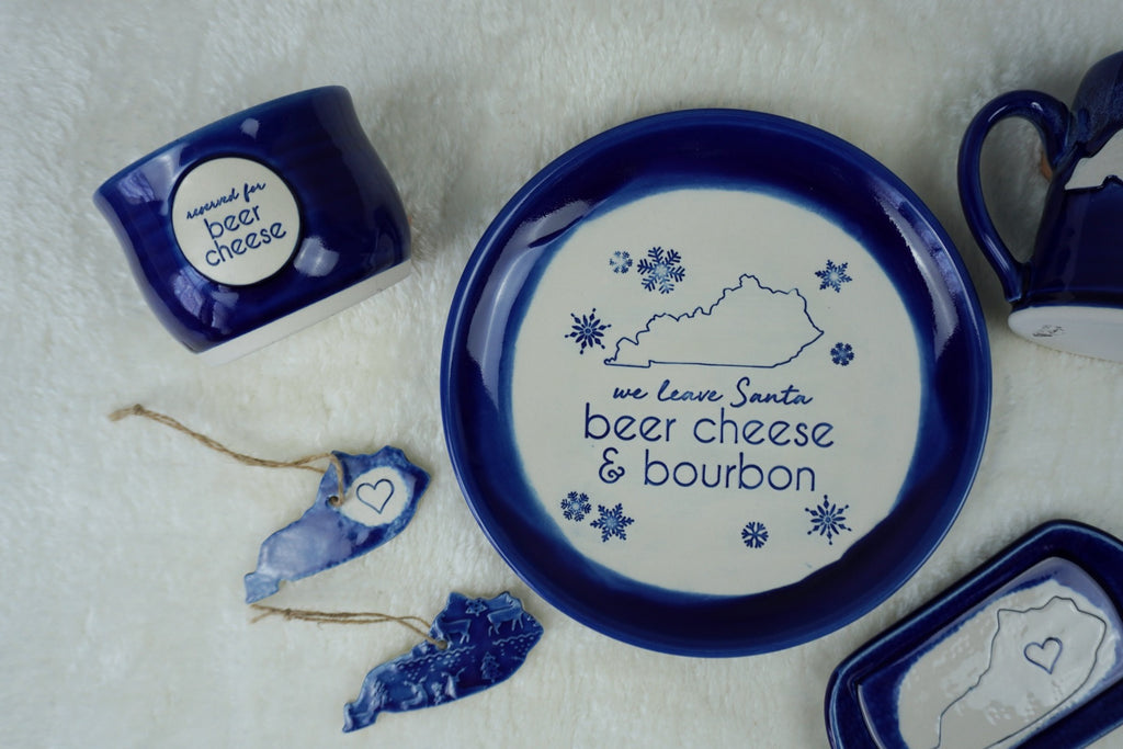 Handmade blue plate with 'we leave Santa beer cheese and bourbon" , the state of Kentucky, and snowflakes stamped into it. Gift for bourbon enthusiast, bourbon gift idea, gift for parents, bourbon decor, Santa plate, Kentucky gift